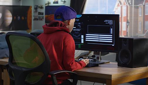 从背后看一个男孩在用电脑编程