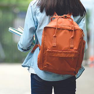 High school student carrying bookbag
